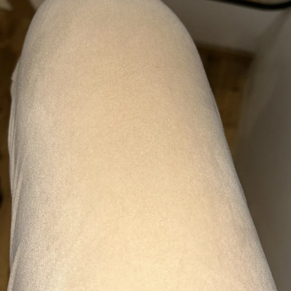 Snygga beige byxor med en tight passform. De är lågmidjade och har en stilren design som passar perfekt för en avslappnad look. Materialet ser mjukt och bekvämt ut, vilket gör dem idealiska för vardagsbruk.. Farkut & Housut.