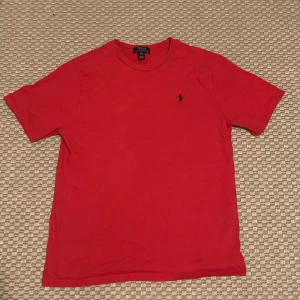 Röd t-shirt från Polo Ralph Lauren - Säljer en röd Ralph Lauren t-shirt. Tröjan har nästan aldrig används och den har inga märken eller hål i sig. Storlek XL men känns som M.