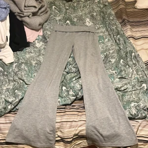 Grå mjukisbyxor - Säljer ett par grå mjukisbyxor med bootcut-stil. Byxorna har en bred linning och är perfekta för en avslappnad look. De är tillverkade i ett mjukt och bekvämt material. En fläck som jag inte vet vad det är 