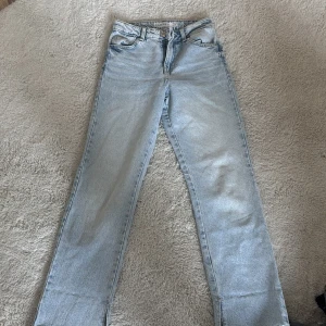 Ljusblå jeans med slits från Amisu - Snygga ljusblå jeans från Amisu med slitsdetaljer vid bensluten. De har en klassisk femficksdesign och en bekväm passform. Perfekta för en avslappnad stil.