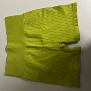 Träningsshorts - Snygga gul/gröna ribbade shorts med hög midja. Perfekta för en avslappnad och trendig look. De har en tight passform som framhäver figuren.