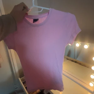 Rosa t-shirt från Gina Tricot - Säljer en söt rosa t-shirt från Gina Tricot i storlek XS. Den har en klassisk rund halsringning och korta ärmar. Perfekt för en avslappnad stil. 💖knabbt använd 
