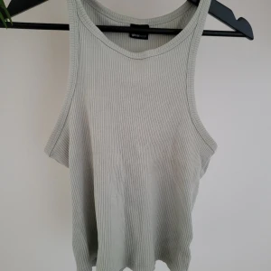 Grå ribbad topp, Gina Tricot - Snygg grå ribbad linnetopp från Gina Tricot. Brottarmodell,  cropad