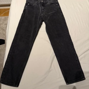 Svarta jeansbyxor - Snygga svarta jeansbyxor med en klassisk straight passform. De har en midwaist design och är perfekta för en stilren look. Byxorna har knappar och dragkedja framtill. W:30 längd 30 pris kan diskuteras 150