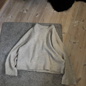 Grå stickad tröja från Gina Tricot - Säljer en mysig grå/beige stickad tröja från Gina Tricot i storlek S. Tröjan har en croppad passform med långa ärmar och ribbade kanter vid ärmslut och nederkant. Perfekt för kyliga dagar! Nypris: 399, men jag säljer för 199. dm mig för frågor 💗💕Pris kan diskuteras!!🤍