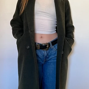 Mörkgrön kappa från MNG - Snygg mörkgrön kappa från MNG i ullblandning. Den har en klassisk design. 🧥storlek S