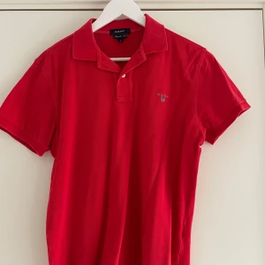 Röd pikétröja från GANT - Snygg röd pikétröja från GANT i regular fit. 