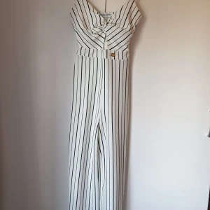 Jumpsuit - Snygg vit byxdress i väldigt bra skick. Den är i storlek S. Skriv gärna över funderingar.