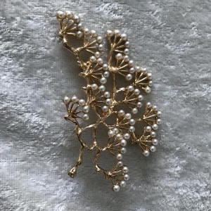 Stora Guldfärgad brosch med pärlor - Elegant guldfärgad brosch formad som en gren med små vita pärlor. Perfekt för att ge en lyxig touch till din outfit. Den intrikata designen gör den till ett unikt smycke. Ca 7.00 cm helt ny, finns fler kvar 