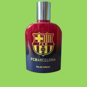 FC Barcelona Eau de Toilette - Snygg Eau de Toilette i en röd och blå flaska med FC Barcelonas emblem. Perfekt för fotbollsfans som vill ha en doft som matchar deras passion för laget. Flaskan har en silverfärgad kork och en stilren design.