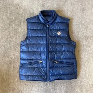 Moncler Gui Vest - Snygg blå dunväst från Moncler. Använd en vår annars helt ny. Köpt för 9299kr, kvitto går säkert att hitta. Skick 10/10 storlek är 3 