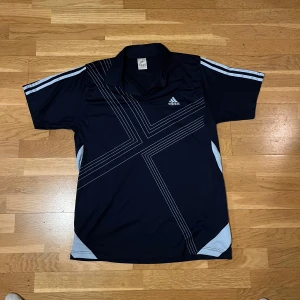 Adidas Piké - Atletisk Adidas piké i marinblå. 