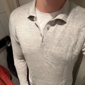 Långärmad piké John Henric  - En väldigt snygg piké i vit/grå melerad färg