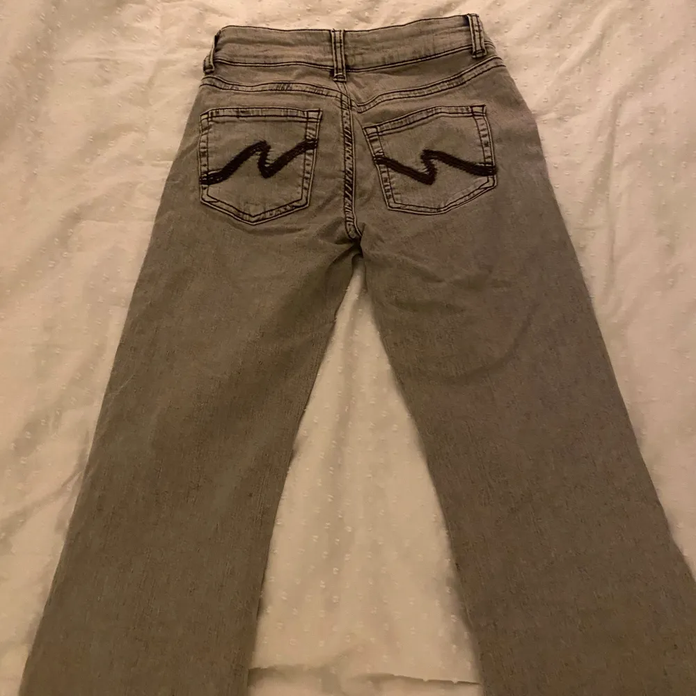 Snygga grå lågmidjade bootcut jeans med unika broderade detaljer på bakfickorna. De har en klassisk femficksdesign och en bekväm passform. Köpta för 700kr på nelly. Använda vid 2 tillfällen och inga tecken på defekter. Innerben: 84 cm (jag är 173cm) Hör av dig vid frågor💞. Farkut & Housut.
