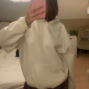 Vit hoodie - Säljer en mysig vit hoodie med en klassisk design. Den har en stor ficka framtill och en bekväm huva. Perfekt för en avslappnad stil. !Tvättar innan frakt!