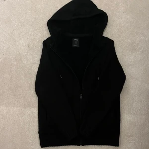 Fodrad Cardigan Jacka - Säljer en svart fodrad cardigan jacka. Den har en dragkedja framtill och en mysig huva. Insidan är quiltad för extra värme och komfort. Perfekt för kyliga dagar! Vid minsta fråga eller fundering hör av er🤝