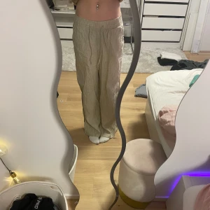 Beige linnebyxor  - Linnebyxor med en avslappnad passform. De är tillverkade i ett lätt och luftigt material som passar bra för varmare dagar.