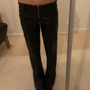 Svarta skinnbyxor med dragkedja - Snygga svarta skinnbyxor. De är lågmidjade och kommer från barnavdelningen på Gina💗de är i stl 158 men passar mig som jag xs och ör 166 cm lång!! Nypris: 350🤍