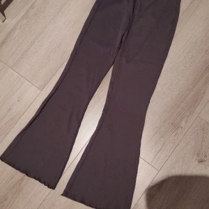 Bruna ribbade byxor från Lindex - Säljer ett par bruna ribbade byxor från Lindex i barnstorlek 134/140. Byxorna har en utsvängd stil och är tillverkade i ett mjukt och bekvämt material. Perfekta för en avslappnad look.