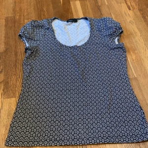 Blommig topp från Lindex - Säljer en söt blommig topp från Lindex i svart och vitt. 