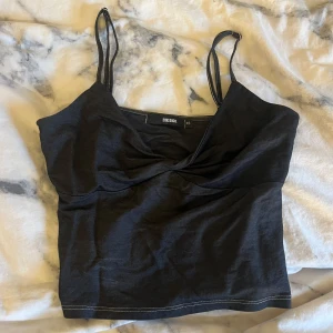 Svart linnetopp från Bik Bok - Snygg svart linnetopp från Bik Bok med smala axelband och en enkel design. Perfekt för en stilren look. Passar bra till både jeans och kjol.