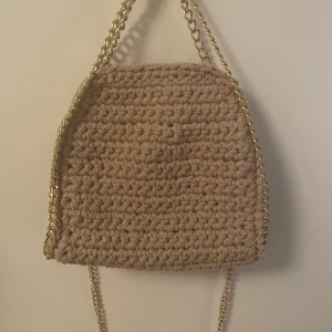 Stella McCartney liknande väska - Så söt Stella McCartney liknande, handgjord, virkad väska. Beige med guldkedja. Ingår en lång kedja och även magnetknapp inuti! Perfekt till alla tillfällen 🩷🩷