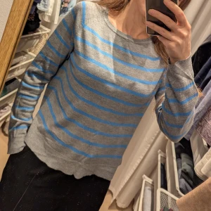 Grå och blå randig tröja från Zara - Säljer en stilren grå tröja med blå ränder från Zara. Tröjan har långa ärmar och en rund halsringning. Perfekt för en avslappnad look. 🩵