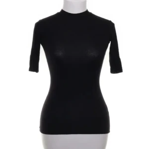 Svart polotopp från Gina Tricot - Snygg svart polotopp från Gina Tricot i en tight passform. Dend använd ett fåtal gånger och är i mycket bra skick. 