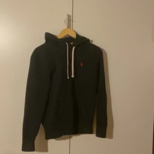 Polo Ralph lauren hoodie - Säljer en svart polo Ralph lauren hoodie i storlek XS. Köpte den för 1900 (såklart äkta). Har använt den ganska mycket, men den är fof i ganska bra skick skulle jag säga. Säljer denna för att den är för liten för mig nu!