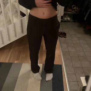 Svarta byxor - Snygga mörkbruna kostymbyxor med en klassisk design. De har en rak passform. Byxorna har en låg midja och är tillverkade i ett bekvämt material. Midjemått: 40 innerbensmåtts: 80cm