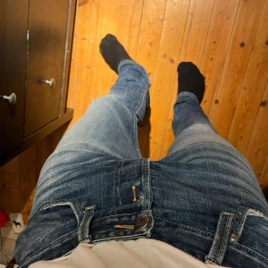 Vintage Replayjeans - Snygga blå jeans från Replay med klassisk femficksdesign och slitna detaljer. De har en knappgylf och är tillverkade i ett robust denimtyg. Perfekta för en avslappnad stil. Går sällan att hitta sånna jeans med denna look.