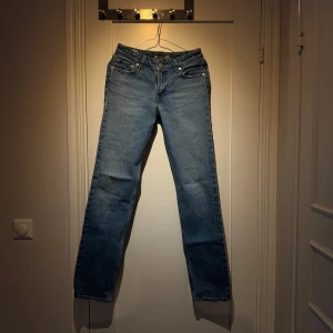 Blå jeans - Snygga blå Levis jeans med klassisk design. De har en rak passform och är perfekta för en avslappnad stil. Jeansen har fem fickor och knappar i midjan.