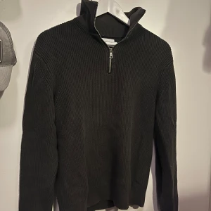 Mörk grön stickad tröja från East West - Säljer en  mörk grön stickad halfzip tröja från East West. 