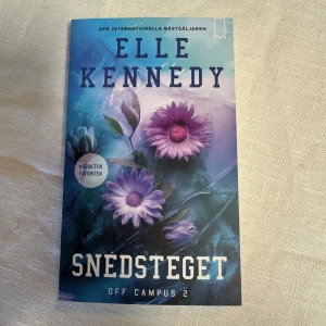 Snedsteget - OFF CAMPUS BOK 2 - Boken 'Snedsteget' av Elle Kennedy är del två i Off Campus-serien. Omslaget pryds av lila blommor mot en blå bakgrund. Den är en internationell bästsäljare och en BookTok-favorit.