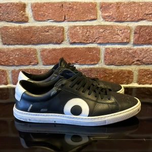 Svarta sneakers från Oliver Cabell - Snygga svarta sneakers från Oliver Cabell med vit sula och vita detaljer. De är lite smutsiga men jag kan tvätta bort det och skicka bild om det finns intresse hör av er vid mer frågor eller prisförslag i dm
