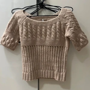 Beige stickad tröja från Maje - Säljer en snygg beige stickad tröja från Maje. Jag skulle säga att den är storlek S Tröjan har ett flätat mönster och trekvartsärmar. Den är både stilren och bekväm, med ribbade kanter som ger en fin passform. Lånade bilder💕