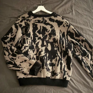 Beige och svart mönstrad stickad tröja från Weekday - Säljer en cool stickad tröja med ett unikt mönster i beige och svart. Tröjan har långa ärmar och ribbade muddar vid ärmslut och nederkant. Perfekt för att sticka ut i mängden! (Weekday) I mycket bra skick använts ett få tal gånger. Väldigt tjock material! Vid snabbt köp kan priset diskuteras!☺️