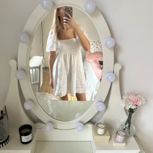 Vit klänning med puffärmar - Charmig vit klänning med puffiga kortärmar och en smickrande passform. Klänningen har en söt och luftig design, perfekt för varma dagar. Den har en fyrkantig urringning och fina detaljer💞använd 1 gång. Köpt för 1200