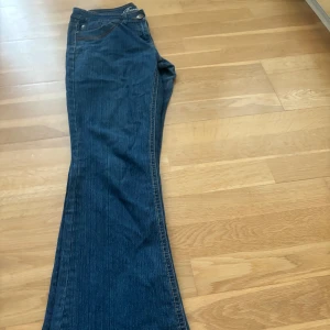 Lågmidjade bootcut jeans  - Lågmidjade utsvängda bootcut jeans med broderi detaljer på bakfickorna. Passar tyvärr inte mig Midjemått: 75 cm Innerbenslängd: 77 cm Hela längden: 98 cm