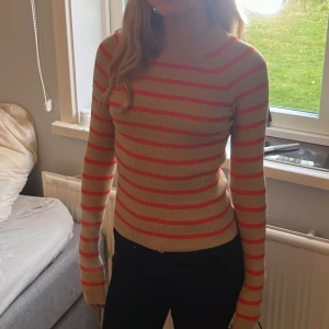 Randig tröja - Långärmad tröja från bikbok i storlek XS men då den är så stretchiga skulle jag säga att den passar upp till M Fint skick! Beige med röd/oragea ränder