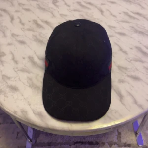 Gucci keps - Hej jag säljer min Gucci keps som jag fick i present, jag sparar till en annan keps och denna är knappt använd.