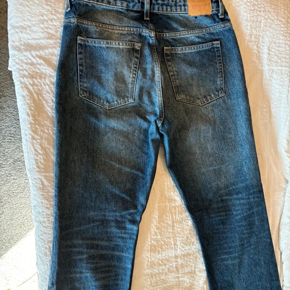 Säljer ett par snygga blå jeans från Weekday i storlek 30/30. De har en femficksdesign och en knappgylf, straight/ bootcut och midwaist. Jeans & Byxor.