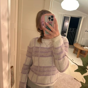 Lila och vit rutig tröja från MNG - Säljer en supermysig lila och vit rutig tröja från Mango. Den är i storlek M men liten i storleken . Perfekt för både vardag och mysiga hemmakvällar!