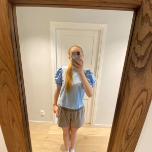 Ljusblå topp med puffärmar från Zara - Säljer en superfin ljusblå topp från Zara med puffiga kortärmar. Den är perfekt för vår och sommar och ger en söt och stilren look. Toppen är i bra skick och passar både till vardags och fest. 💙