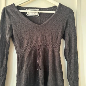 Finstickad tröja  - Finstickad tröja som man knyter i midjan. Bra skick 