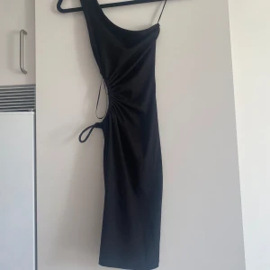 Svart klänning  - Jättefin svart klänning från new yorker. Cut out i midjan, 1axel. Använd fåtal gånger. Storlek xxs.