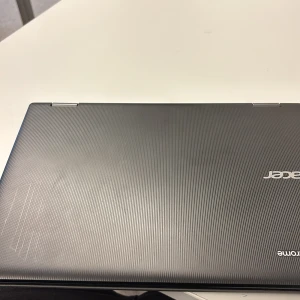 Acer bärbar dator - Säljer en stilren och tunn bärbar dator från Acer. Den har en elegant mörkgrå yta med subtila ränder och en diskret logotyp. Perfekt för både arbete och studier.