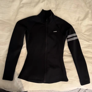 Svart Stronger Signature Zip Jacka - Svart träningsjacka från Stronger i storlek XS. Endast använd ett fåtal gånger. Har några noppror vid ena fickan men annars i stort sett nyskick