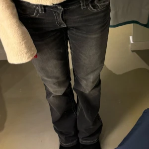 Svarta lågmidjade bootcut jeans - Snygga svarta bootcut jeans med vita sömmar. Jätte snygga och har fickor på baksidan. De är från Gina  i storlek 164 men passar som xs.