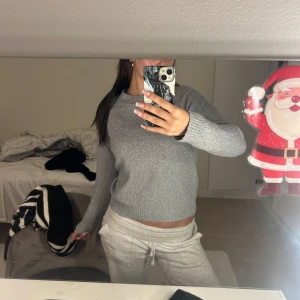 Grå stickad tröja - Säljer en mysig grå stickad tröja med rund hals och långa ärmar. Perfekt för kyligare dagar och enkel att matcha med olika outfits.